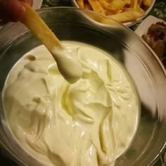 a person dipping some kind of sauce in a bowl