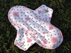 a white and pink polka dot blanket laying on the grass