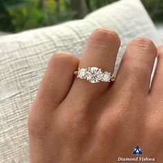 a woman's hand with a three stone ring on top of her left hand