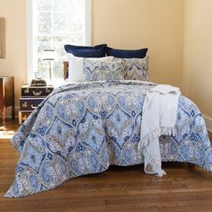 a blue and white comforter set on a bed