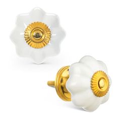 two white and gold flower shaped knobs on a white background, one with a golden center