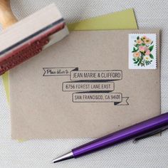 a close up of a envelope with a stamp on it and a pen next to it