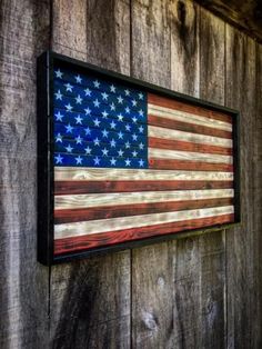 an american flag is hanging on a wooden wall