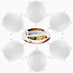 a person holding a bowl with food in it and eight plates around it on the table