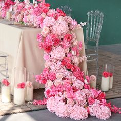 the table is set with pink flowers and candles