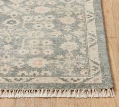 a rug with fringes on the floor in front of a wooden flooring area