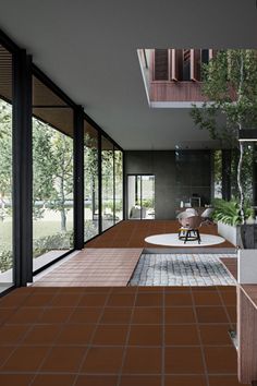 an empty room with lots of windows and furniture on the floor, in front of trees