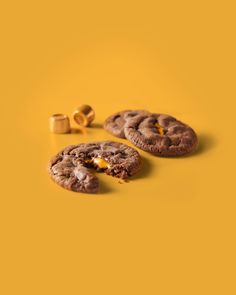 three cookies with one broken in half on a yellow background