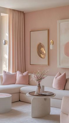 a living room with pink walls and white furniture in the corner, along with paintings on the wall