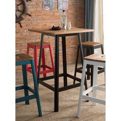 three stools and a table in front of a brick wall