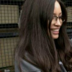 a woman with long brown hair and glasses