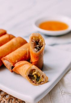 some food is on a white plate with dipping sauce