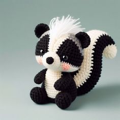 a crocheted stuffed animal is posed on a gray surface with its tail up