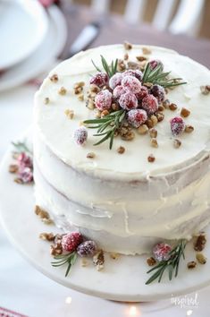 a white cake with frosting and sprinkles on it sitting on a plate