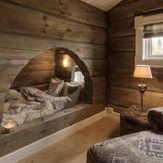 a bedroom with wooden walls and flooring has a bed made out of wood planks