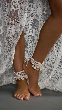 a woman's feet wearing white lace barefoot sandals