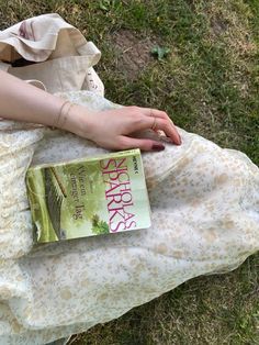 a person laying on the ground with a book