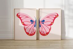 two pink and blue butterfly paintings in front of a white wall with wood flooring