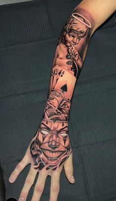 a person's arm with tattoos on it and an evil face in the middle