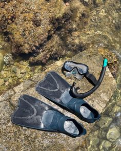 two pairs of diving equipment sitting on top of a rock