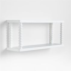 a white wall shelf with beads hanging from it's sides, against a white background