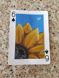 a playing card with a sunflower painted on it