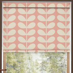 a pink and white patterned roman blind in front of a window