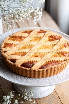 a pie sitting on top of a white cake plate