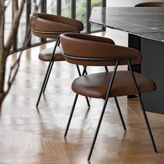 the chairs are lined up on the wooden floor near the table in the dining room