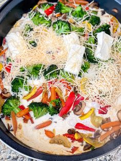 a pan filled with vegetables and cheese on top of a table