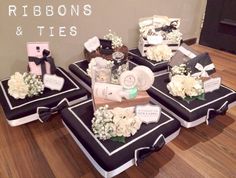 four black and white boxes with flowers on them sitting on a wooden floor next to a wall