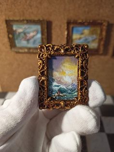 someone holding up a miniature painting in their hand