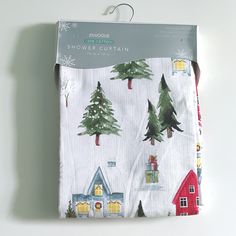 the packaging is wrapped in white paper with christmas trees and houses on it's side