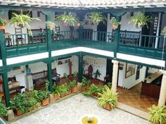 an indoor courtyard with potted plants on the balconies and two story balcony