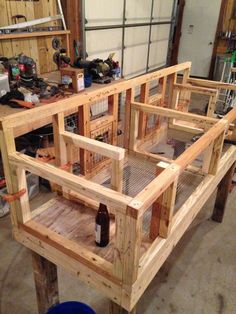 a wooden bench made out of pallets in a garage with tools on the floor