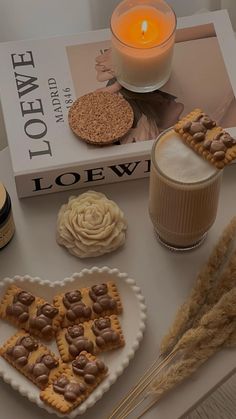 a table topped with lots of desserts next to a candle