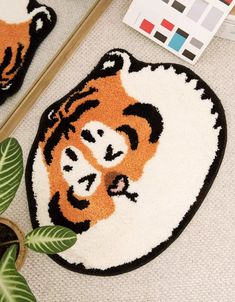 a tiger rug is on the floor next to a potted plant and a mirror