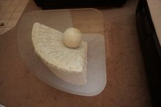 a piece of cheese sitting on top of a plastic tray next to a microwave oven