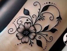 a black and white flower tattoo on the side of a woman's leg,