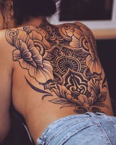 the back of a woman's shoulder with flowers on it