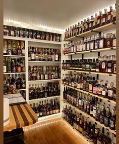 a room filled with lots of bottles and shelves full of different types of liquors