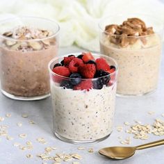 three small cups filled with oatmeal, berries and nuts on a table