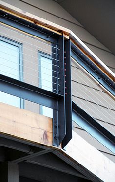 the side of a house that has a window on it and a balcony attached to it