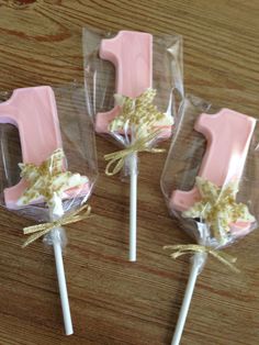 three pink lollipops wrapped in cellophane and tied with twine