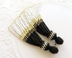 two black and white beaded hair clips on top of a lace doily,