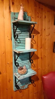 a wooden shelf with two shelves on each side and a candle in the middle next to it