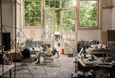 a man sitting in a chair inside of a room filled with lots of clutter