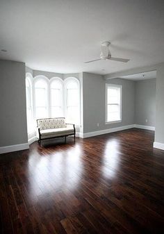 an empty living room with hard wood floors and white trim on the windows is shown