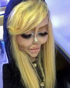 a woman with long blonde hair and nose piercings