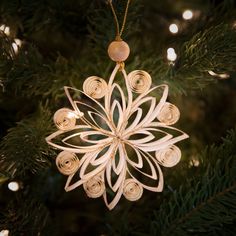 an ornament hanging from a christmas tree in the shape of a snowflake